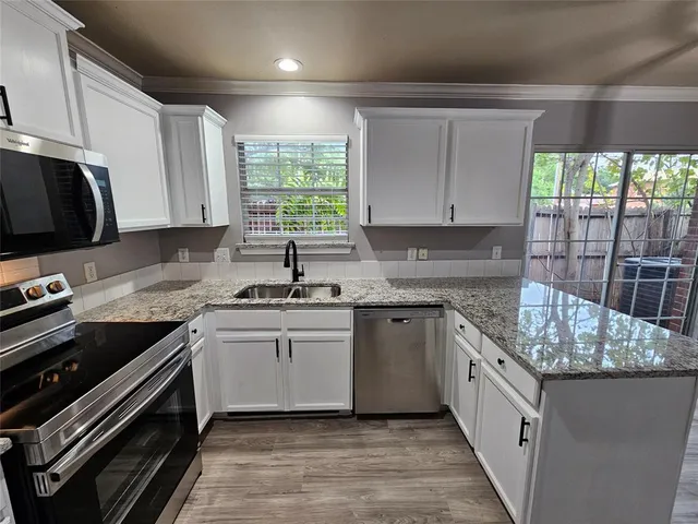 a kitchen with stainless steel appliances granite countertop a sink stove and cabinets