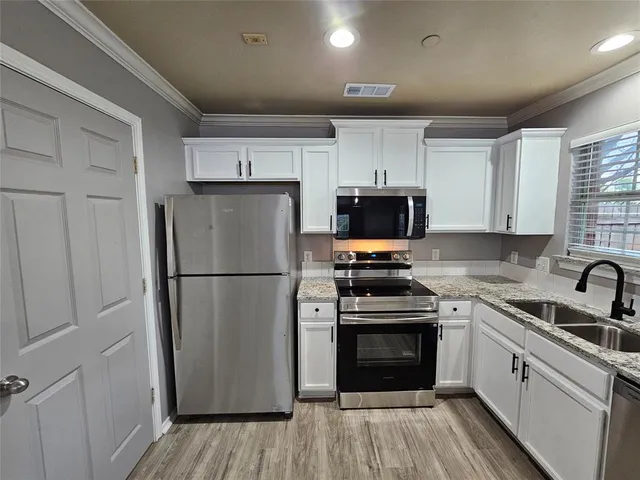 a kitchen with a refrigerator sink and stove top oven
