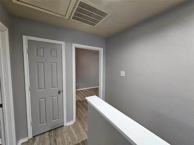 an empty room with a ceiling fan and wooden floor