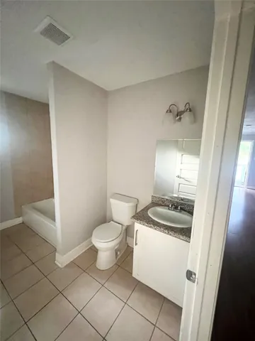 a bathroom with a sink a toilet a mirror and vanity