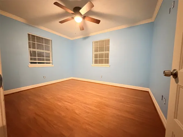 an empty room with a window and a ceiling fan