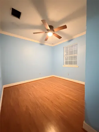 a view of a backyard with large trees and wooden fence