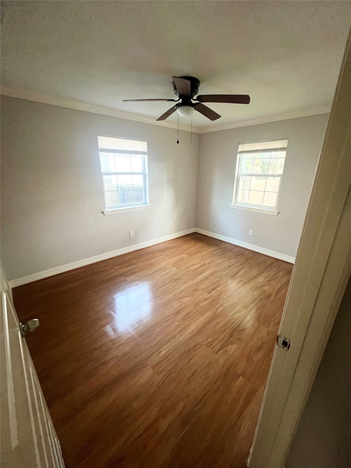 110 Gans Street Houston, TX 77029 - Photo 14 of 17 an empty room with wooden floor ceiling fan and windows