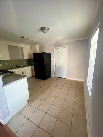 a view of kitchen with cabinets and refrigerator