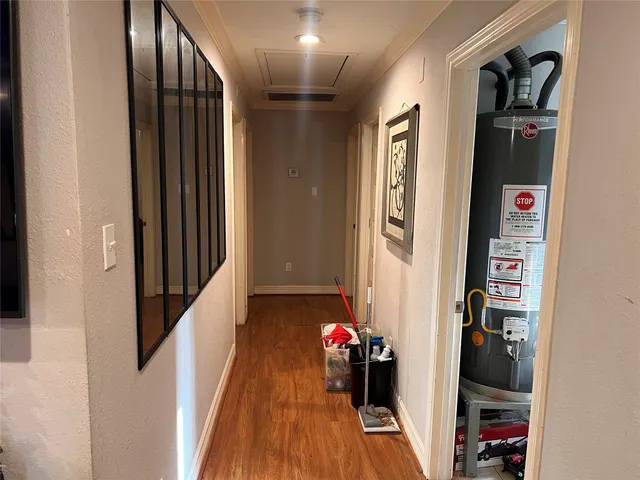 a view of a hallway with wooden floor and closet
