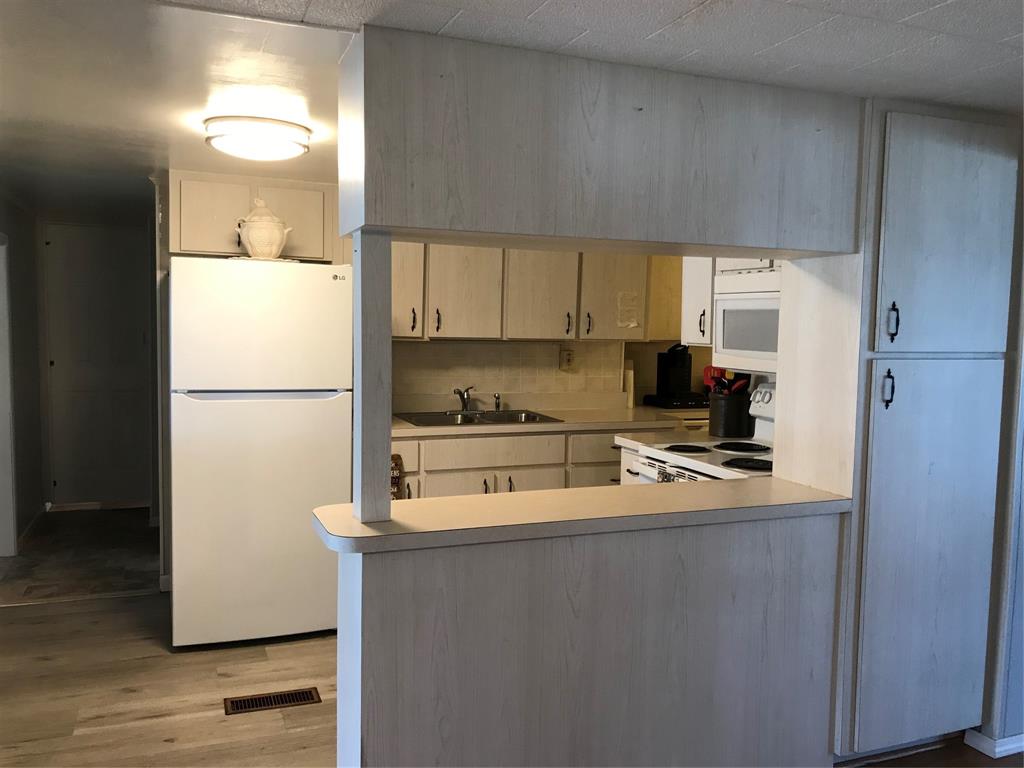 1112 Southeast 21st Street Okeechobee, FL 34974 - Photo 14 of 20 a kitchen with a refrigerator a stove a microwave and cabinets