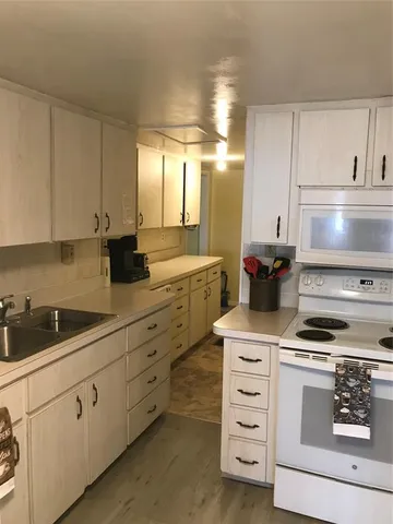 a kitchen with cabinets appliances and a sink