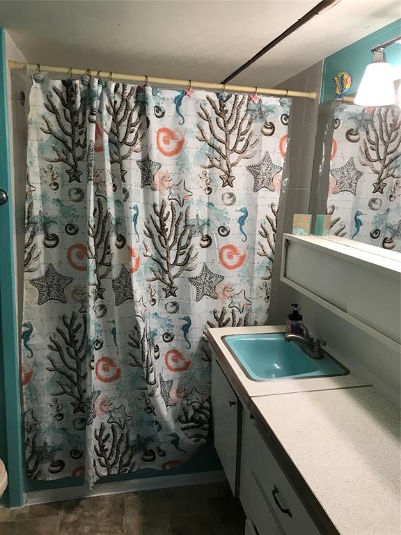 1112 Southeast 21st Street Okeechobee, FL 34974 - Photo 18 of 20 a bathroom with a granite countertop sink and a shower curtain