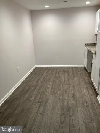 an empty room with wooden floor and cabinets