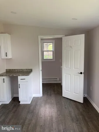 an empty room with wooden floor and cabinet