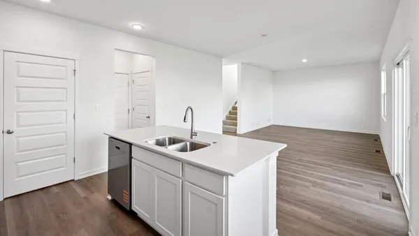 a kitchen with a sink cabinets and wooden floor