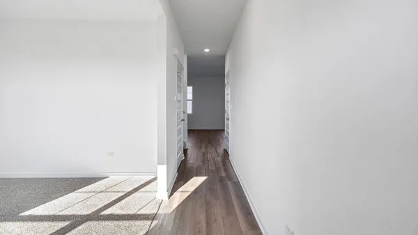 a view of a hallway with wooden floor