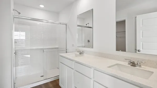 a bathroom with a double vanity sink mirror and shower