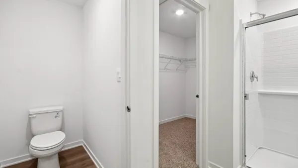 a bathroom with a granite countertop toilet and a sink