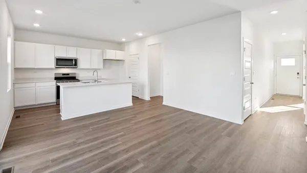 a kitchen with stainless steel appliances a stove top oven a sink and a refrigerator