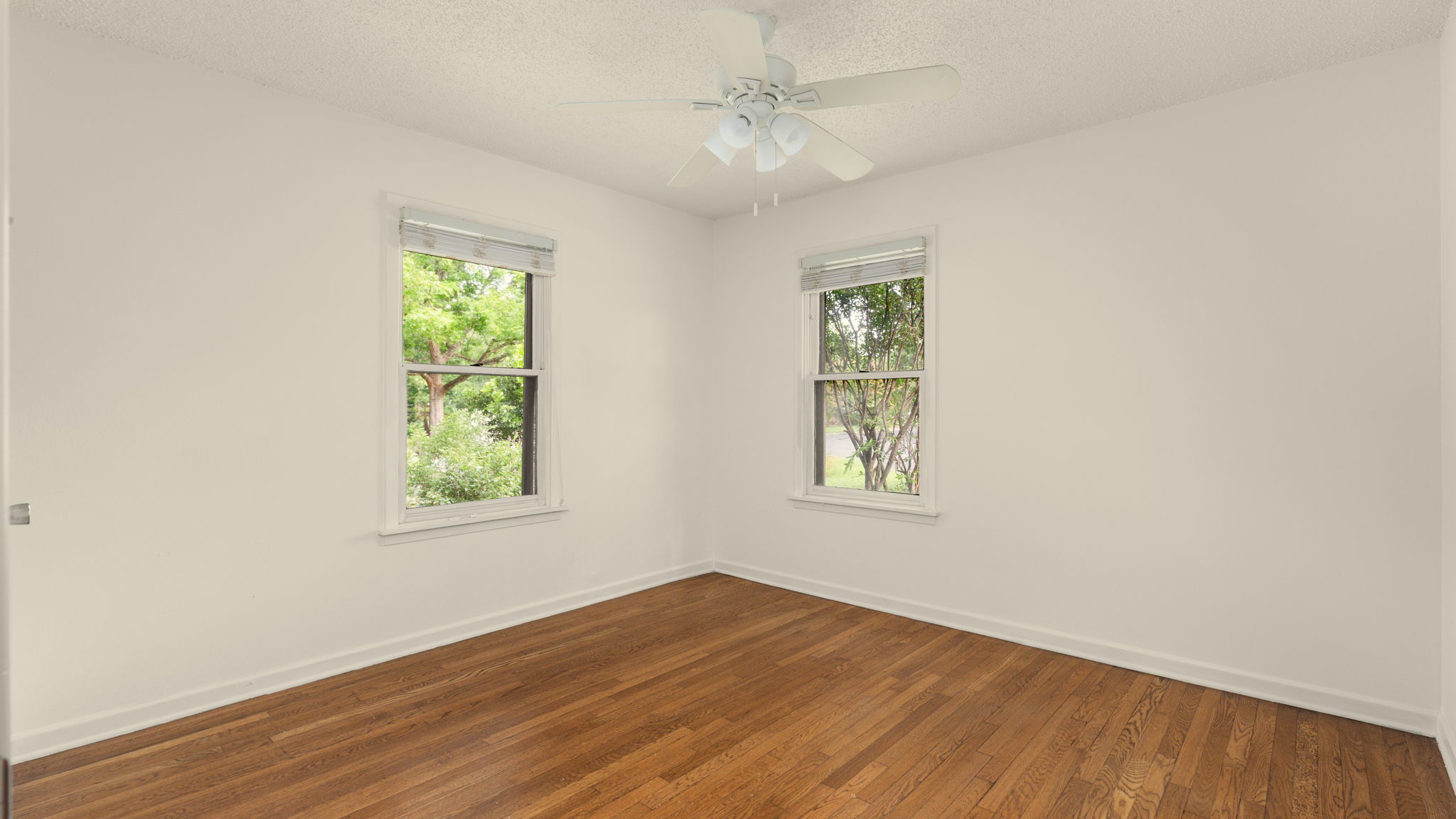 206 East Skyview Road Austin, TX 78752 - Photo 16 of 32 1st bedroom Hardwood floors and generous windows grace this inviting, naturally illuminated bedroom.