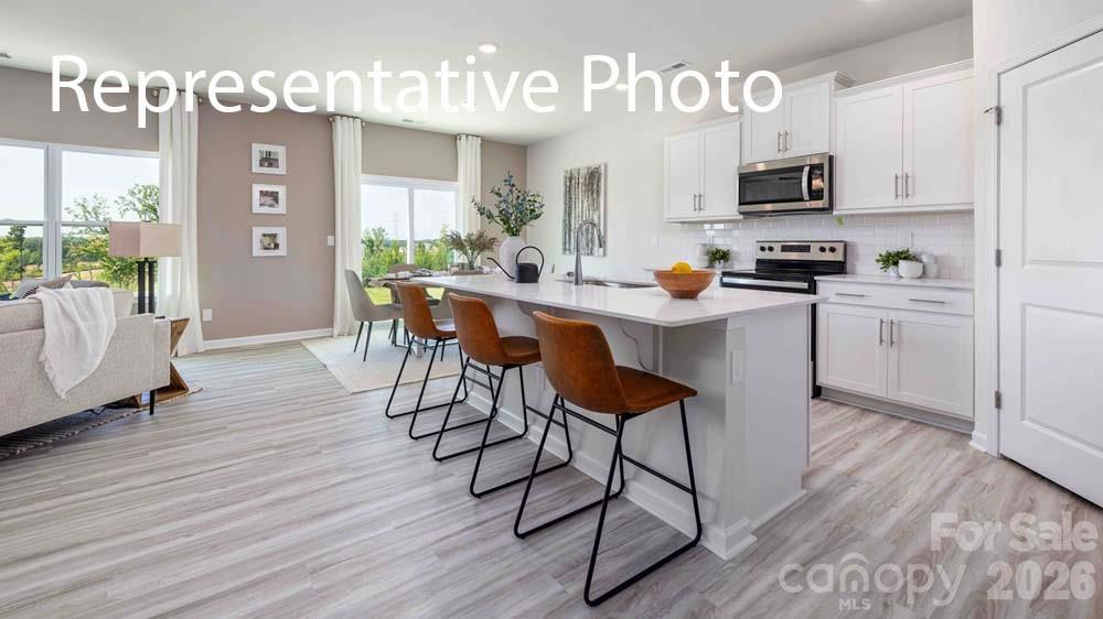 7592 Bainbridge Road Sherrills Ford, NC 28673 - Photo 2 of 28 a kitchen with stainless steel appliances a dining table chairs microwave and sink
