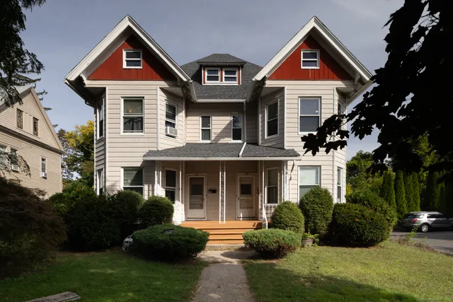 a front view of a house with a yard and trees