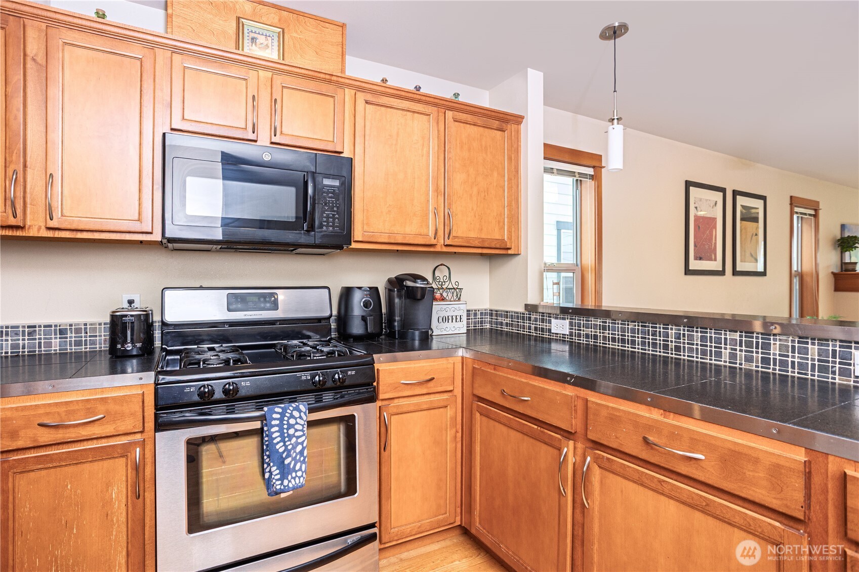 3314 Wetmore Avenue South, Unit B Seattle, WA 98144 - Photo 11 of 28 a kitchen with stainless steel appliances granite countertop a stove a sink and a microwave