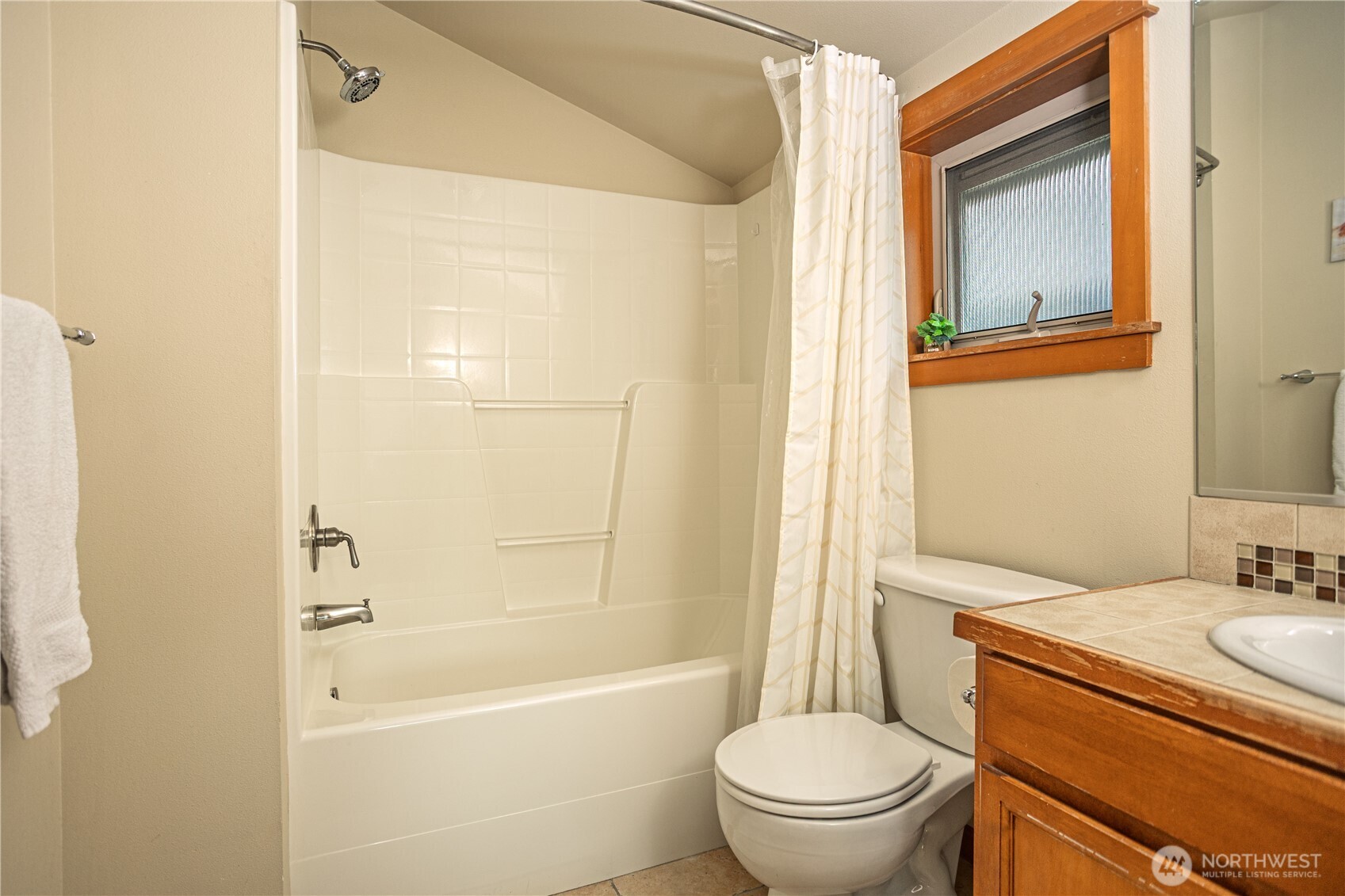 3314 Wetmore Avenue South, Unit B Seattle, WA 98144 - Photo 17 of 28 a bathroom with a granite countertop toilet a sink and a bathtub