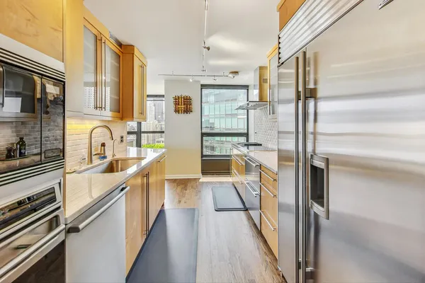 a view of a kitchen with a sink and refrigerator