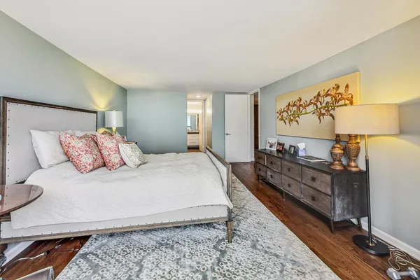 a large bedroom with a bed and wooden floor