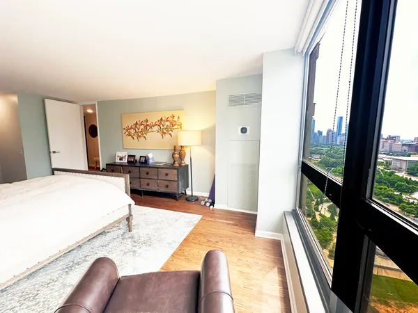 a bedroom with a bed and a large window