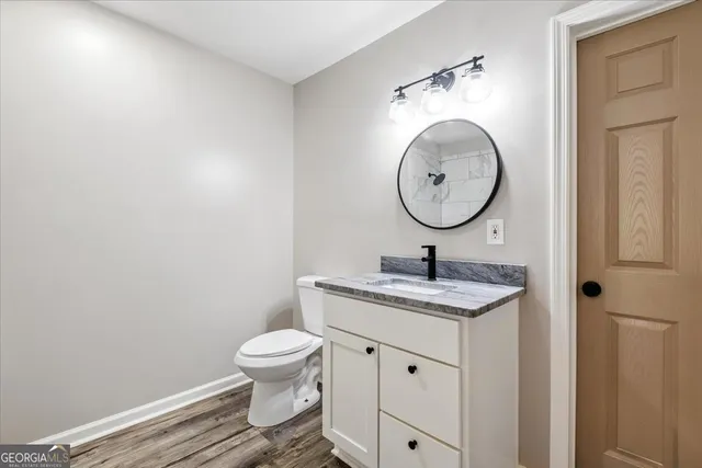 a bathroom with a toilet a sink and a mirror
