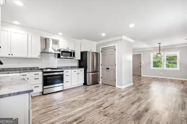 a kitchen with stainless steel appliances kitchen island granite countertop a stove a sink and a refrigerator