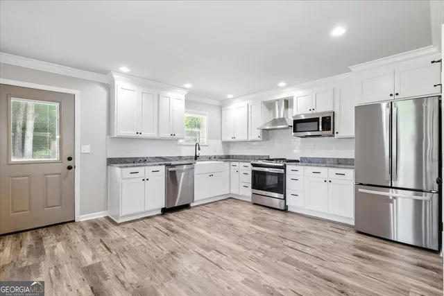a kitchen with granite countertop white cabinets and stainless steel appliances