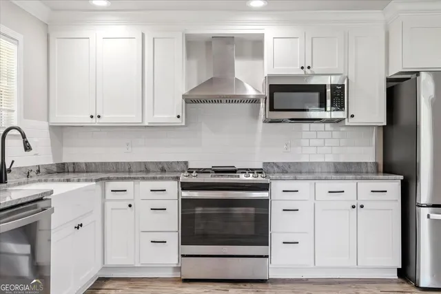 a kitchen with white cabinets and stainless steel appliances