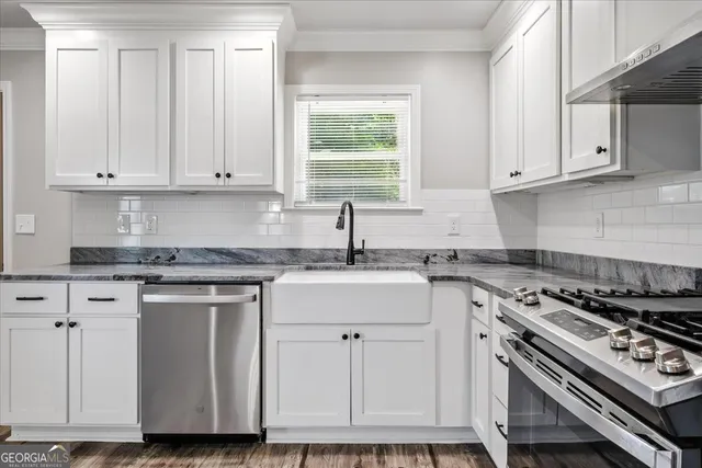 a kitchen with granite countertop a stove sink and cabinets