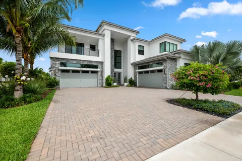 a front view of a house with a yard and potted plants