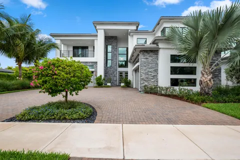 a front view of a house with a yard and potted plants