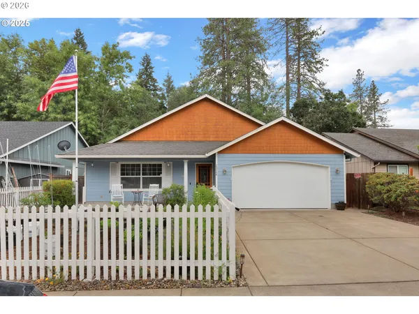 a front view of house with yard and trees in the background