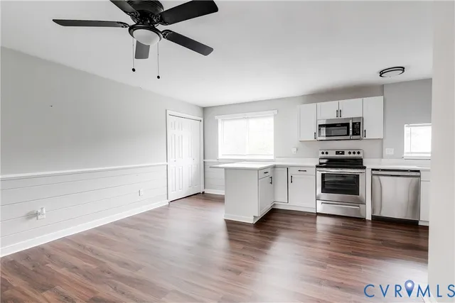 a kitchen with granite countertop a refrigerator and a stove top oven
