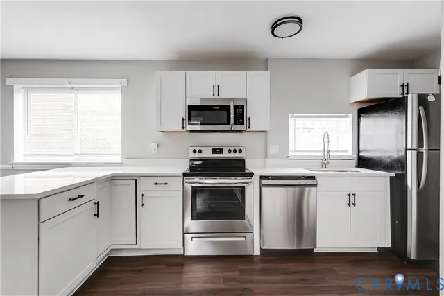a kitchen with stainless steel appliances a stove a sink and a microwave