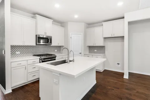 a kitchen with a sink appliances and cabinets