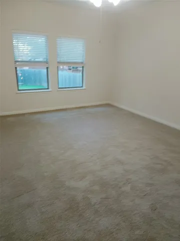 a view of empty room with wooden floor and window