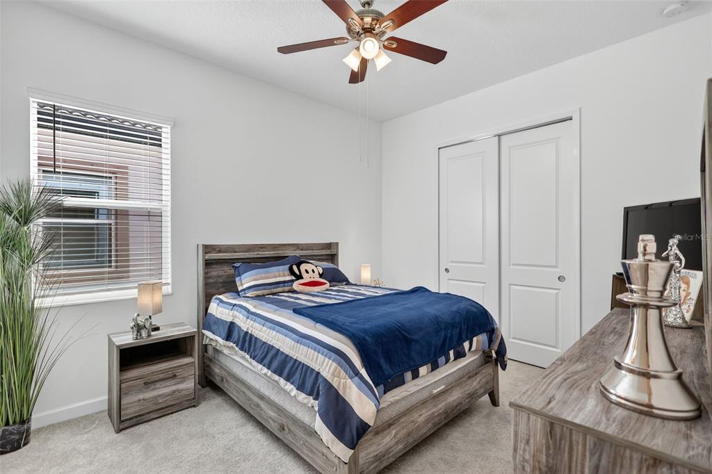 17109 Star Banks Street Wimauma, FL 33598 - Photo 26 of 60 a bedroom with a bed and a chandelier