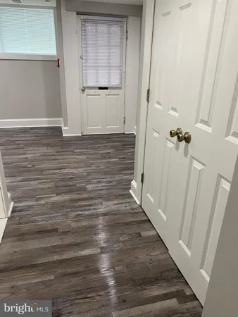 a view of a hallway with wooden floor and entryway