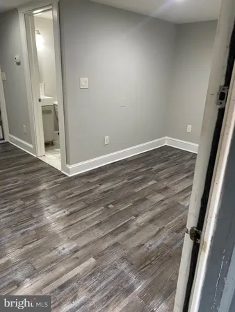 en empty room with wooden floor and mirror