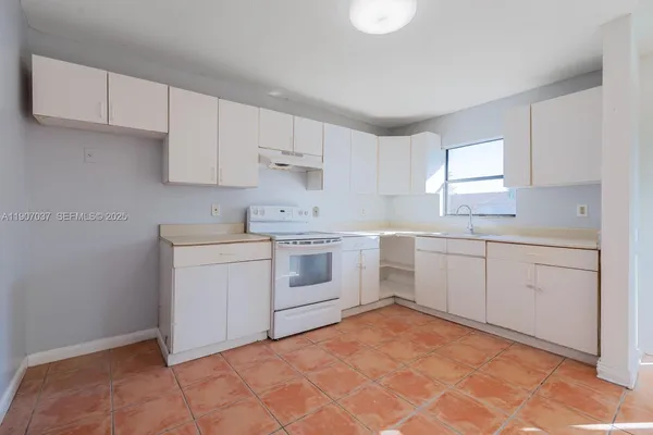 a kitchen with white cabinets stainless steel appliances and sink