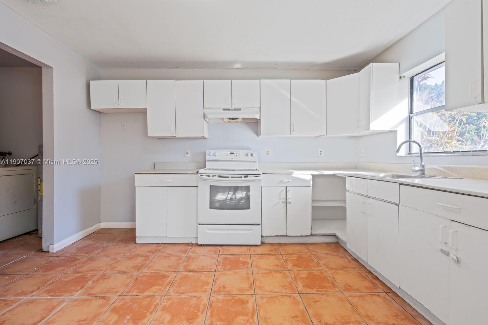 28147 Southwest 142nd Court Homestead, FL 33033 - Photo 7 of 16 a kitchen with white cabinets and white appliances