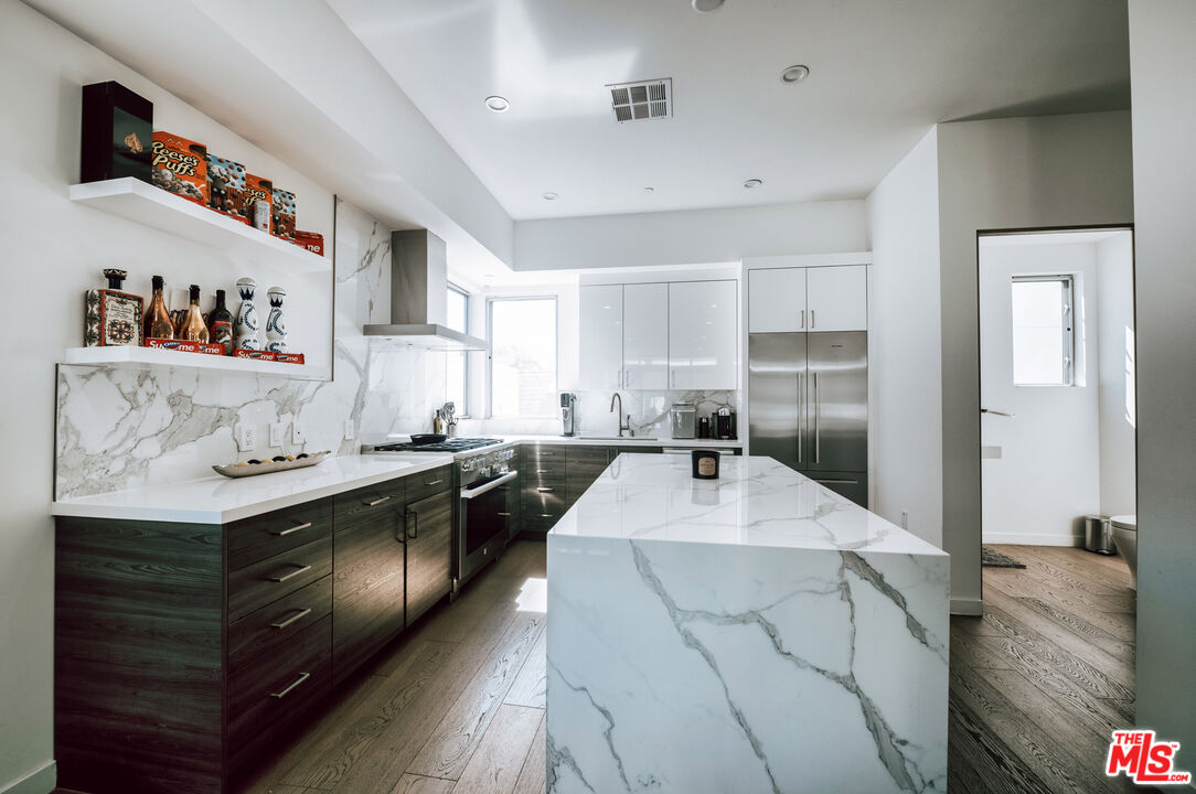 a large kitchen with stainless steel appliances granite countertop a sink stove and refrigerator