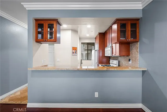 a kitchen with stainless steel appliances granite countertop a stove a sink and a microwave