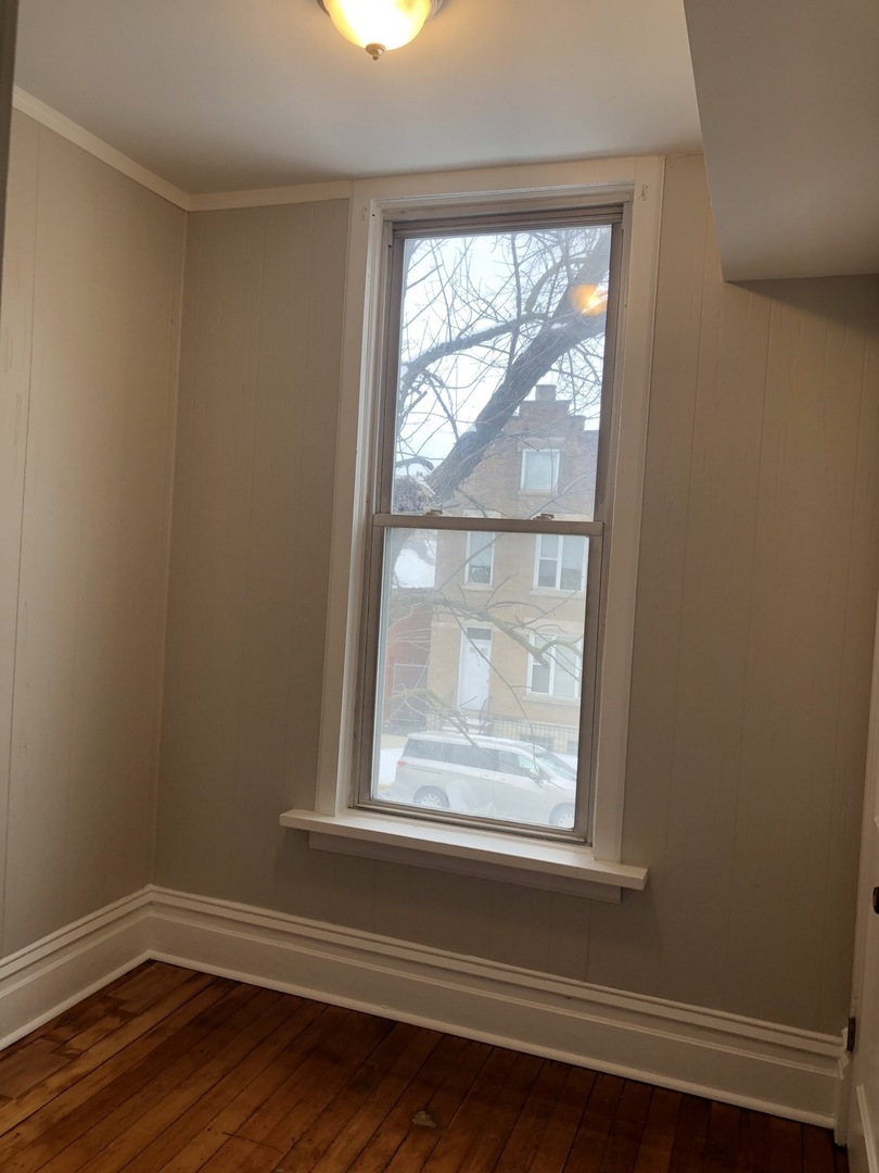 827 West 33rd Place, Unit 2F Chicago, IL 60608 - Photo 18 of 23 a view of empty room with wooden floor and fan