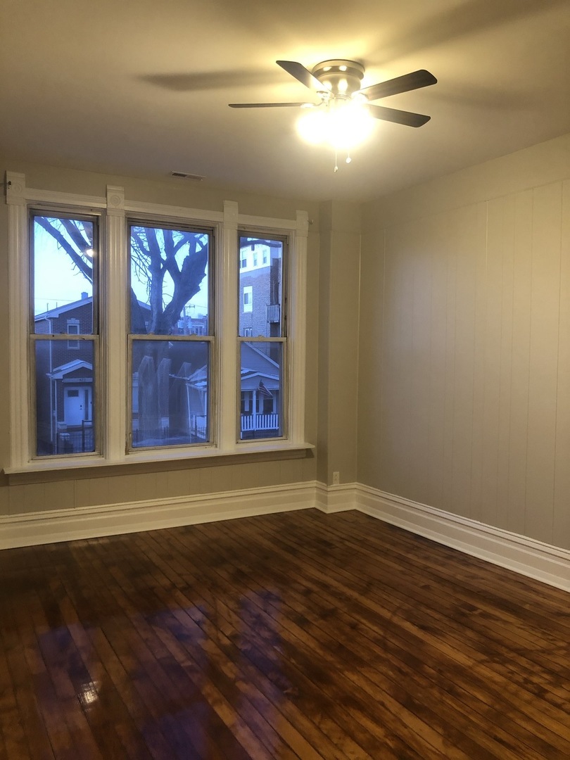 827 West 33rd Place, Unit 2F Chicago, IL 60608 - Photo 7 of 23 a view of empty room with wooden floor and fan