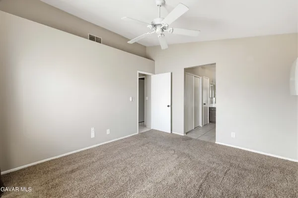 a view of an empty room with a ceiling fan