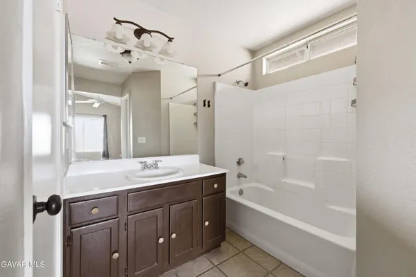 a bathroom with a tub sink and mirror
